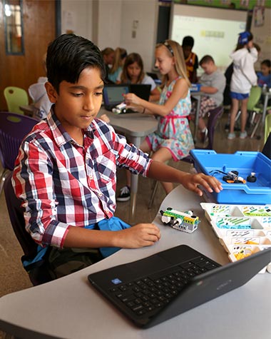 A Picture of a boy using a computer and working on a lego project